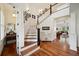 Open foyer with hardwood floors, a staircase with white railings, and views of the living room at 3011 River Vista Way, Mount Pleasant, SC 29466