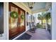 Inviting double front door featuring two wreaths, rocking chairs and wood flooring on the porch at 3011 River Vista Way, Mount Pleasant, SC 29466