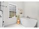 Bright bathroom featuring a modern soaking tub and a stylish accent table next to a window at 32 Middleton Oaks Rd, Charleston, SC 29414