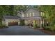 Beautiful two-story home with a covered front porch, two-car garage, and a gravel driveway surrounded by mature trees at 32 Middleton Oaks Rd, Charleston, SC 29414