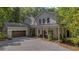 Beautiful two-story home with a covered front porch, two-car garage, and a gravel driveway surrounded by mature trees at 32 Middleton Oaks Rd, Charleston, SC 29414
