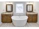 Luxurious bathroom featuring a standalone tub, dual granite vanities, and wood look tile flooring at 321 Houston Dr, Ladson, SC 29456