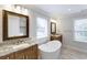 Elegant bathroom featuring dual granite vanities, modern fixtures, and a standalone tub at 321 Houston Dr, Ladson, SC 29456