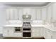 Well-lit kitchen featuring bright white cabinetry, stainless steel appliances, mosaic tile backsplash and quartz countertops at 321 Houston Dr, Ladson, SC 29456