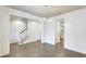 Bright living room with hardwood floors, white shiplap walls, modern chandelier, and view of the stairway and kitchen at 321 Houston Dr, Ladson, SC 29456