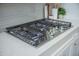 Close-up of a modern gas cooktop with sleek stainless steel knobs and a white countertop at 331 Fish Creek Ct, Summerville, SC 29486
