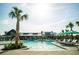 Community pool with palm trees, lounge chairs, umbrellas, and a view of the clubhouse in the background at 365 Trailmore Ln, Summerville, SC 29486