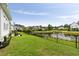 Expansive backyard with lush green lawn and a black fence bordering a serene pond at 3726 Orion Ln, Mount Pleasant, SC 29466