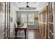Well-lit home office with hardwood floors, ceiling fan, large window and a cabinet with louvered doors at 3726 Orion Ln, Mount Pleasant, SC 29466