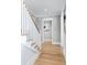 Bright hallway with hardwood floors and staircase featuring white wooden railings at 3741 Juneberry Ct, Mount Pleasant, SC 29466