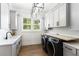 Well-lit laundry room with modern washer and dryer, cabinets for storage, and butcher block folding counter at 3741 Juneberry Ct, Mount Pleasant, SC 29466