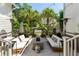 A patio with white couches surrounding a concrete fire pit, palm trees and string lights at 3741 Juneberry Ct, Mount Pleasant, SC 29466