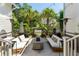 A patio with white couches surrounding a concrete fire pit, palm trees and string lights at 3741 Juneberry Ct, Mount Pleasant, SC 29466