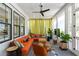 Cozy sunroom with an orange sectional sofa, lots of sunlight, and views of the surrounding greenery at 3741 Juneberry Ct, Mount Pleasant, SC 29466
