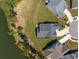 Aerial view showcasing a house with a well-manicured lawn, located next to a picturesque lake at 393 Tupelo Lake Dr, Summerville, SC 29486