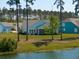 Spacious backyard overlooking a serene pond, lush green grass, and surrounded by tall trees at 393 Tupelo Lake Dr, Summerville, SC 29486