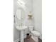 Cozy powder room with a pedestal sink, round mirror, decorative shelf, and elegant fixtures at 393 Tupelo Lake Dr, Summerville, SC 29486