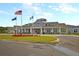 Clubhouse featuring well-maintained landscaping, American flags, and a paved circular driveway at 393 Tupelo Lake Dr, Summerville, SC 29486