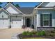 Inviting home front entrance with a two-car garage and beautiful landscaping at 393 Tupelo Lake Dr, Summerville, SC 29486