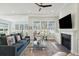 Cozy living room with a fireplace, large windows offering water views, and comfortable seating arrangements at 393 Tupelo Lake Dr, Summerville, SC 29486