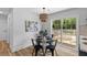 Bright dining area featuring a glass table, seating for four, stylish chandelier, and sliding glass doors to deck at 411 Berkeley Dr, Moncks Corner, SC 29461