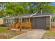 Charming brick home featuring a new wooden porch, well-manicured lawn, and attached garage at 411 Berkeley Dr, Moncks Corner, SC 29461
