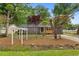 Charming brick home with inviting pergola, mature trees, manicured lawn, and a cozy swing on the front porch at 411 Berkeley Dr, Moncks Corner, SC 29461