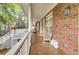 A covered back porch with brick siding, two chairs, and wood floors at 4217 Meadowbrook Ct, North Charleston, SC 29420