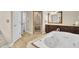 This bathroom has a tiled shower and soaking tub with wood vanities and counters at 4217 Meadowbrook Ct, North Charleston, SC 29420