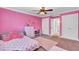 A pink bedroom featuring carpet, a ceiling fan, and an open doorway creates a vibrant, playful space at 4217 Meadowbrook Ct, North Charleston, SC 29420