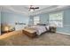 A tranquil bedroom boasts blue walls, tray ceilings, a ceiling fan, and cozy carpet at 4217 Meadowbrook Ct, North Charleston, SC 29420