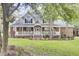 Stately two-story home with a wraparound porch, featuring classic architectural details and a neatly landscaped front yard at 4217 Meadowbrook Ct, North Charleston, SC 29420