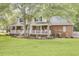 Beautiful two-story home with a covered front porch, a well-maintained lawn, and manicured garden beds at 4217 Meadowbrook Ct, North Charleston, SC 29420