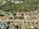 Aerial view of a home nestled in a neighborhood setting with lush greenery all around, emphasized by a red marker at 454 Pooshee Plantation Way, Bonneau, SC 29431