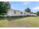 Exterior view showing a well-kept lawn and brick foundation accents at 454 Pooshee Plantation Way, Bonneau, SC 29431