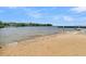 Beach scene with tranquil water and pier in the background, offering a serene spot for relaxation and recreation at 454 Pooshee Plantation Way, Bonneau, SC 29431