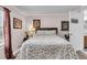 Charming bedroom features hardwood floors, a bed, wall art, and an open bathroom at 454 Pooshee Plantation Way, Bonneau, SC 29431