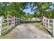 Long driveway framed by mature trees leads to a well-kept home at 454 Pooshee Plantation Way, Bonneau, SC 29431
