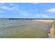 Scenic waterfront view featuring a sandy beach, gentle water, and distant pier, ideal for outdoor relaxation at 454 Pooshee Plantation Way, Bonneau, SC 29431