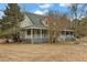 Home exterior showing large, wraparound porch and spacious front yard at 4689 Causey Pond Rd, Awendaw, SC 29429