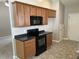 A spacious kitchen featuring wood cabinets, black countertops, and vinyl floors at 4804 Oak Haven Pl, Summerville, SC 29485