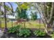 Landscaped backyard with wrought iron fence and view of pond, offering a serene outdoor space at 486 Maple Oak Ln, Charleston, SC 29414