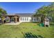 Large backyard featuring a covered patio, playhouse, and meticulously kept lawn at 486 Maple Oak Ln, Charleston, SC 29414