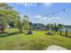 Well-manicured backyard with a pond view and a black metal fence at 486 Maple Oak Ln, Charleston, SC 29414