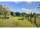 Spacious backyard with pond view, black metal fence, and playhouse at 486 Maple Oak Ln, Charleston, SC 29414