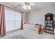 Brightly lit bedroom with a twin bed, bookshelf, window, and pink curtains at 486 Maple Oak Ln, Charleston, SC 29414