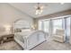 Bright main bedroom with a large bay window, ornate white bed, and a ceiling fan at 486 Maple Oak Ln, Charleston, SC 29414