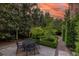 A tranquil backyard seating area surrounded by lush greenery and meticulously manicured hedges at 5 Logan St, Charleston, SC 29401