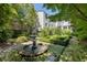 Serene backyard featuring a beautiful fountain, manicured garden beds, and lush greenery at 5 Logan St, Charleston, SC 29401