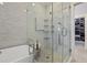 Bathroom featuring a glass-enclosed shower, and a luxurious bathtub with white marbled tile surround at 5 Logan St, Charleston, SC 29401